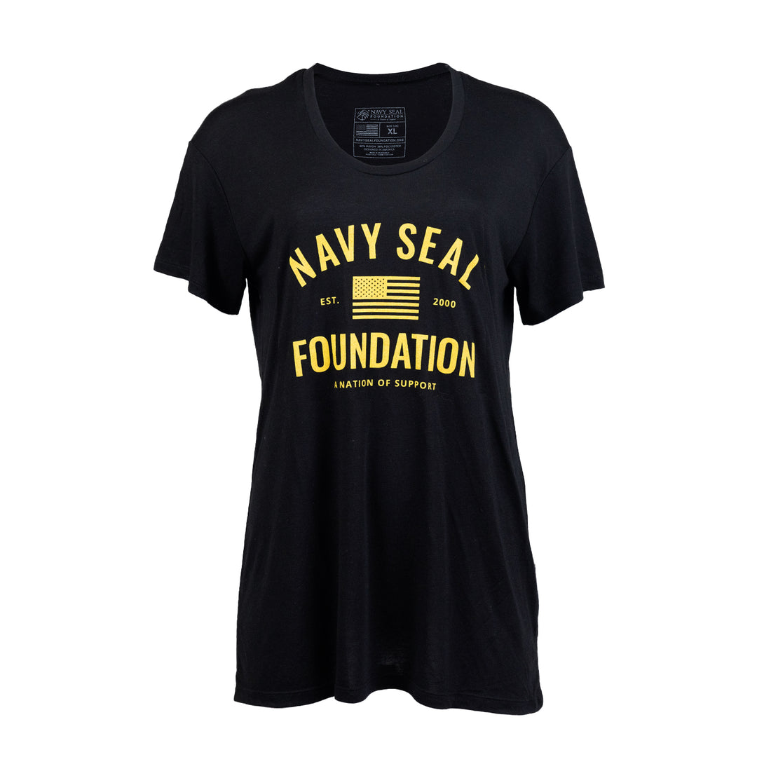 Ladies tee in black with yellow text on front "NAVY SEAL FOUNDATION A NATION OF SUPPORT EST 2000" with graphic of American flag